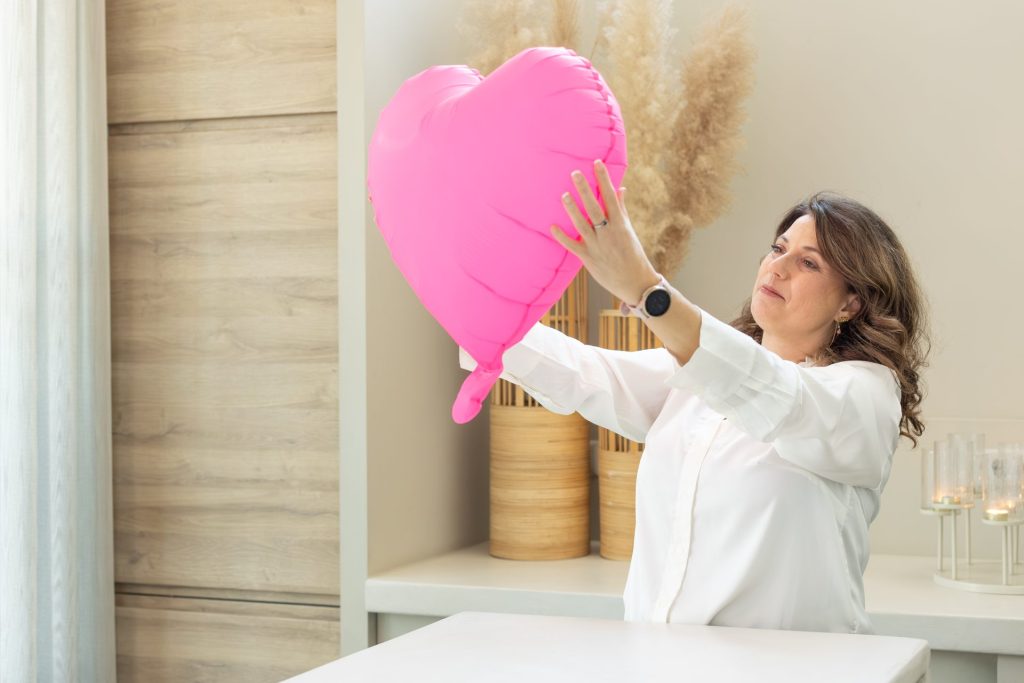 Dimphy kijkt naar een groot roze hart in haar handen